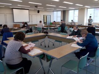 写真：配布文書を見ながら数人が話を聞く様子