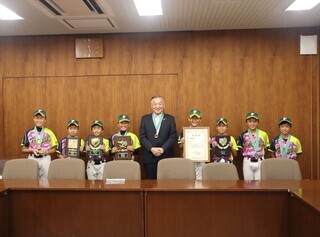 写真：市長と多摩フレンズベースボールクラブの選手が並んで写真を撮っている様子