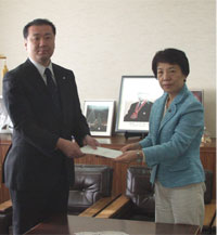 写真：多摩市指定企業指定通知書を京西テクノス株式会社に手渡す多摩市長（誘致指定企業第19-2号）