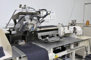 写真：ジーンズのポケットを縫う工業用ミシン