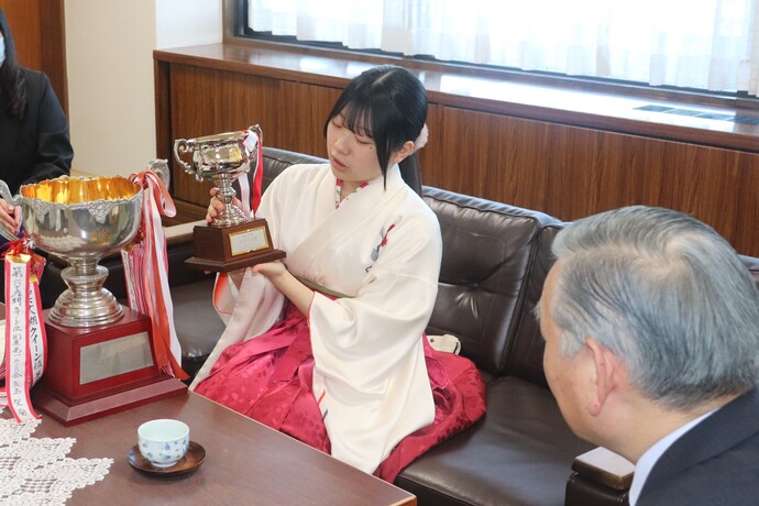 クイーン位獲得のカップを市長に紹介する矢島さん